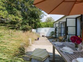 An outdoor dining area with a table and chairs at Burrows in Venn Ottery near Sidmouth