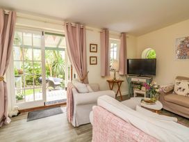 A living room with a sofa and a television at Sunset Cottage Swimbridge near Barnstaple