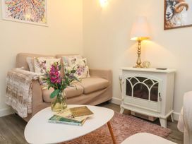 A living room with a sofa, coffee table, and lamp at Sunset Cottage in Swimbridge near Barnstaple