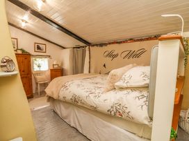 A bedroom with a bed and furnishings at Sunset Cottage in Swimbridge near Barnstaple