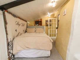 A bedroom with a bed and shelves in Sunset Cottage Swimbridge near Barnstaple
