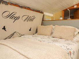 A bedroom with a bed and pillows at Sunset Cottage Swimbridge near Barnstaple