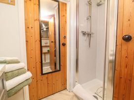 A bathroom with a shower and towels at Sunset Cottage Swimbridge near Barnstaple