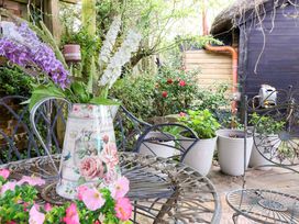 A garden with a table and flower jug at Sunset Cottage Swimbridge near Barnstaple