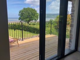 A balcony with a view of a tree and landscape at Worthy Barn in Porlock Weir