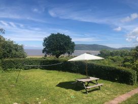 A garden with a table and umbrella at Worthy Barn Porlock Weir