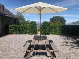 A table with an umbrella in a garden at Worthy Barn Porlock Weir