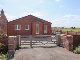 A house with a gravel driveway and a gate at Waverley Cottage in Kilnsea near Easington, Hull