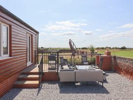 A deck with chairs and a table at Waverley Cottage in Kilnsea near Easington, Hull