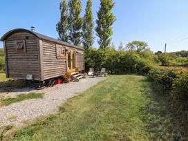 A tiny house with a gravel path and chairs in an outdoor space at Cariad Mawr Gwaenysgor near Prestatyn