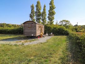A tiny house with chairs on gravel at Cariad Mawr in Gwaenysgor near Prestatyn