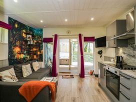 A living room with a sofa and kitchen area at Squirrels Lodge in South Molton