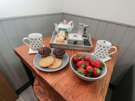 A table with cups, cookies, brownies, and strawberries at Squirrels Lodge in South Molton