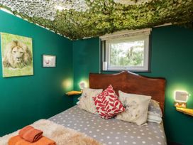A bedroom with a bed and wall decor at Squirrels Lodge in South Molton
