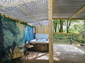 An outdoor patio featuring a hot tub and seating at Squirrels Lodge in South Molton