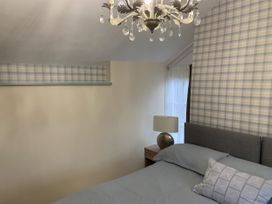 A bedroom with a bed and lamp at Woods Cottage in Usk