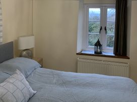 A bedroom with a bed and window at Woods Cottage Usk
