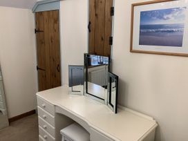 A bedroom with a vanity unit and mirrors at Woods Cottage Usk