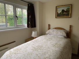 A bedroom with a bed and window at Woods Cottage in Usk