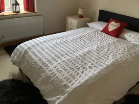 A bedroom with a bed and nightstand at Woods Cottage in Usk