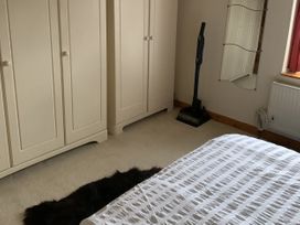 A bedroom with a wardrobe and a vacuum cleaner at Woods Cottage Usk