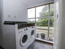 A laundry room with washing machine and tumble dryer at Woods Cottage in Kingcoed near Raglan