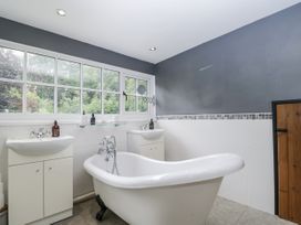 A bathroom with a bathtub and sinks at Woods Cottage near Raglan