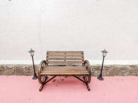 A wooden bench with lamps beside it at Woods Cottage in Kingcoed near Raglan