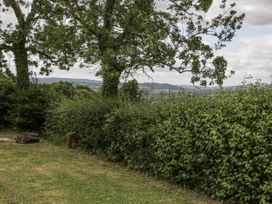 A garden with trees and bushes at Woods Cottage in Kingcoed near Raglan