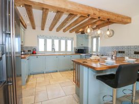A kitchen with wooden beams and blue cabinets at Cuckoo Pen Cottage in Eastham near Tenbury Wells