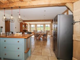 A kitchen with an island and a dining area with a wooden table and chairs at Cuckoo Pen Cottage in Eastham near Tenbury Wells