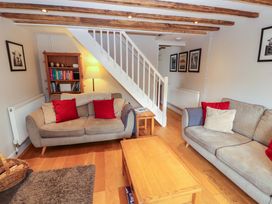 A living room with a sofa, coffee table, and bookcase at Byways in Ambleside