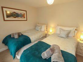 A bedroom with two beds and bedside tables at Byways in Ambleside