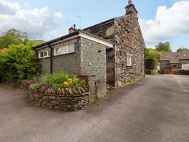An outdoor view of a stone house with a flower bed at Byways Ambleside