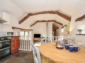 A kitchen with a dining table and television at Skiber Long Bray Shop near Launceston