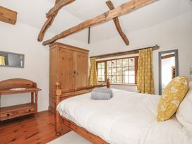 A bedroom with a bed and wardrobe at Skiber Long in Bray Shop near Launceston