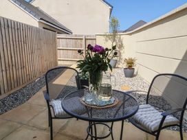 A garden with a table and chairs and flowers at Seashell Sands in Appledore