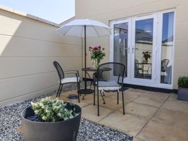 An outdoor patio with a table and chairs at Seashell Sands in Appledore