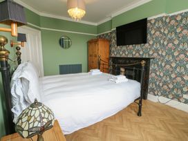 A bedroom with a bed and wardrobe at Noah's Rest in Llandudno