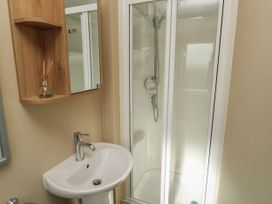 A bathroom with a sink and shower cabin at A La Mer in Paignton