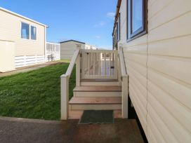Steps with a railing and a gate leading to a deck next to a mobile home at A La Mer in Paignton