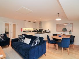A living room with a sofa and dining area at 39 Dart Marina in Dartmouth