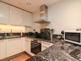 A kitchen with cabinets, countertop, sink, oven, microwave, and kettle at 39 Dart Marina Dartmouth