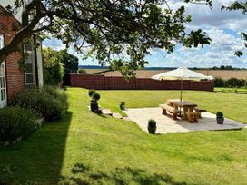 A garden with a table and umbrella at Knights Farm in Harkstead