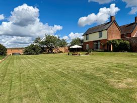 A garden with a house and patio at Knights Farm in Harkstead