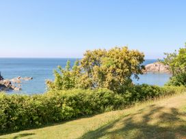 A coastal view with trees bushes grassy area and ocean at Ocean View in Combe Martin