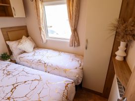 A bedroom with two single beds and a window at 25 Kingfisher Court in Tattershall