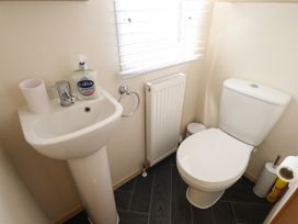 A small bathroom with a pedestal sink a toilet a radiator a window with blinds and a soap dispenser at 25 Kingfisher Court in Tattershall