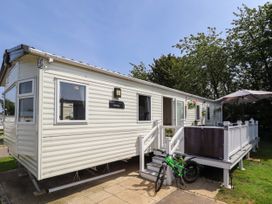 A mobile home with a veranda a green bicycle and an umbrella at 25 Kingfisher Court in Tattershall