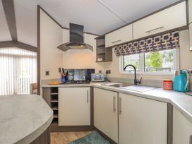 A kitchen with a gas stove a toaster a kettle and a sink with a window at The Boathouse in St Leonards-On-Sea